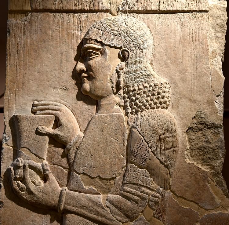 This is an Assyrian eunuch, holding a cup; its bottom is in the shape of a ...